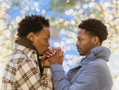 a Black LGBTQ couples hold hands and look into each other's eyes